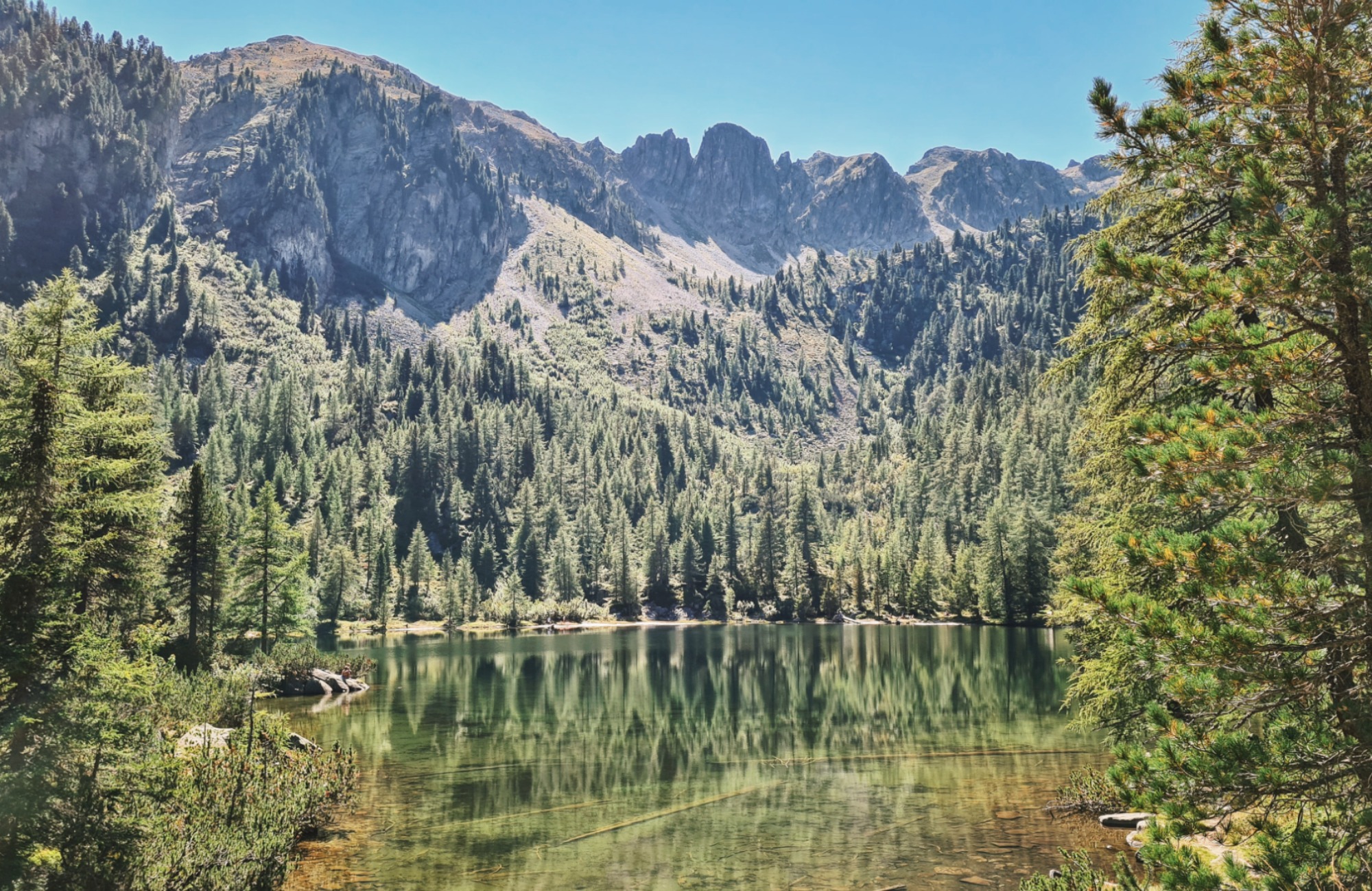 Emerald green water of a mountain lake with mountain peaks in the background