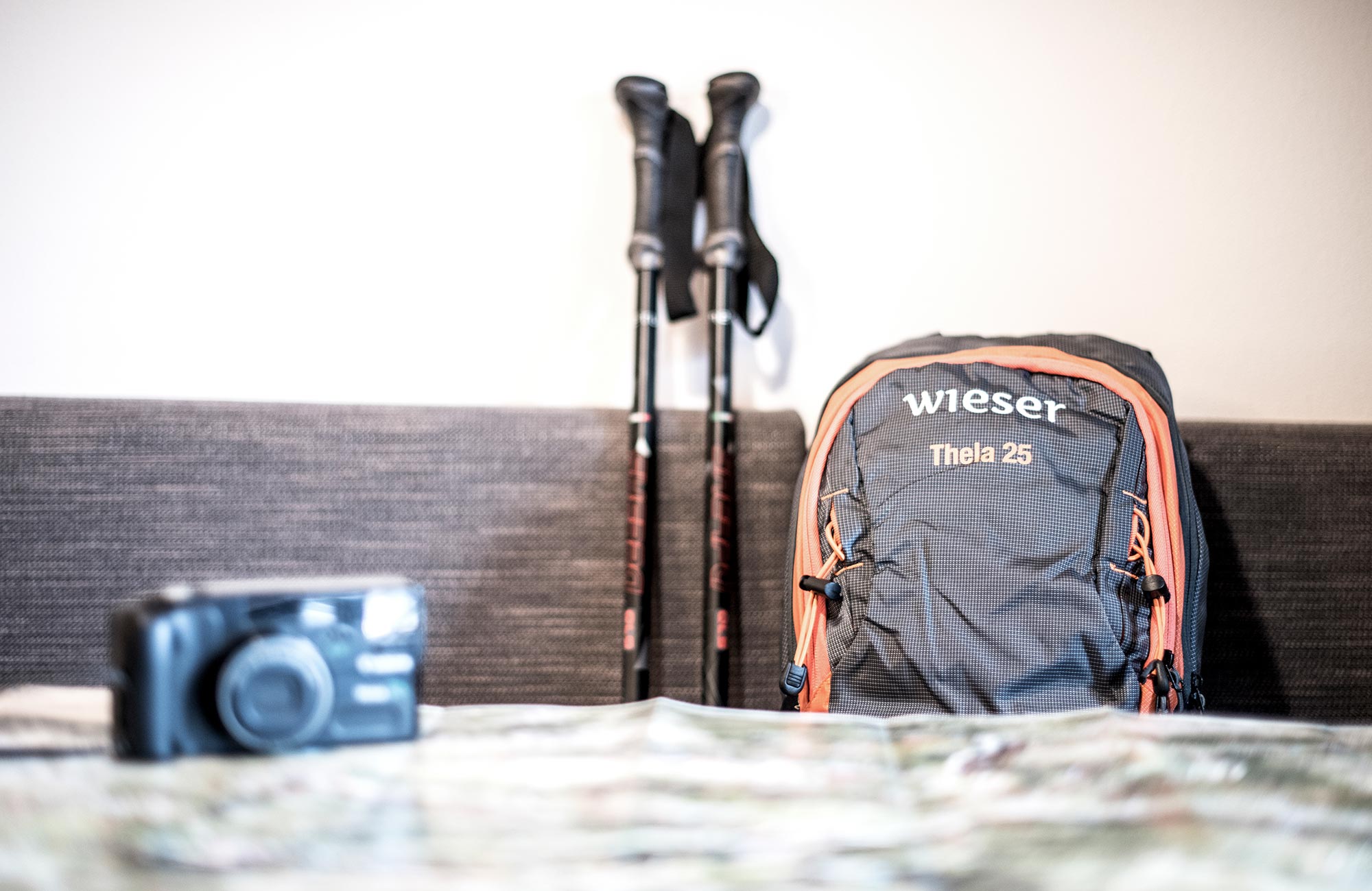 A backpack, hiking poles and a camera on the bench - Hotel Wieser