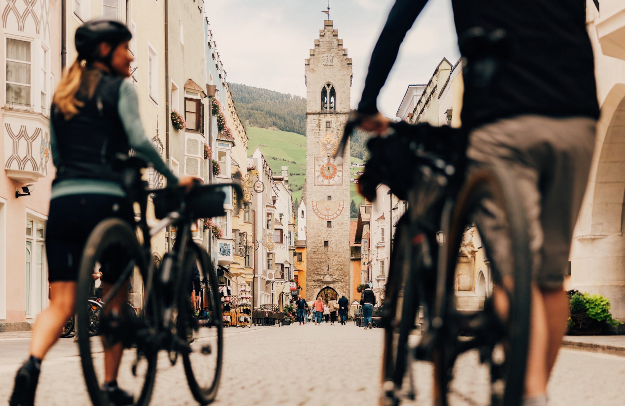 Two cyclists in front of the Zwölferturm in Vipiteno - Hotel Wieser