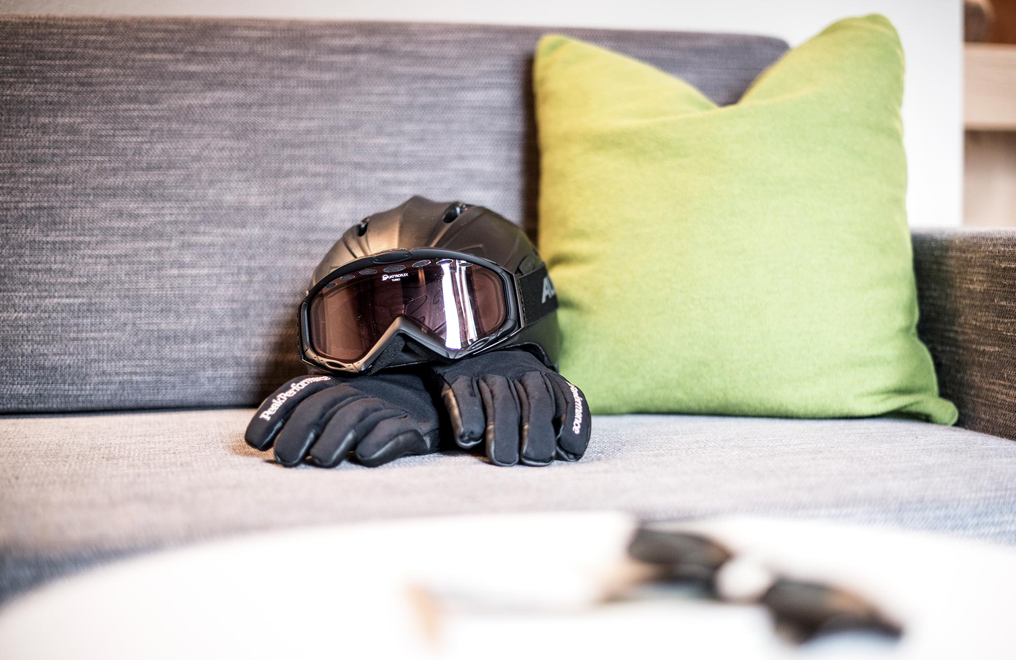 Two hiking boots and a helmet with ski goggles on the sofa - Hotel Wieser