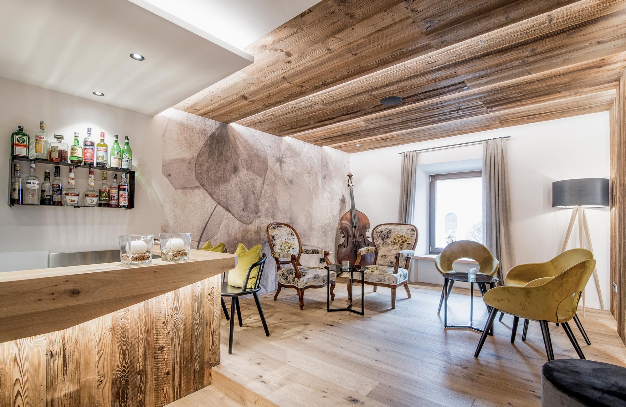 Lounge with chairs, tables, and a bar - Hotel Wieser