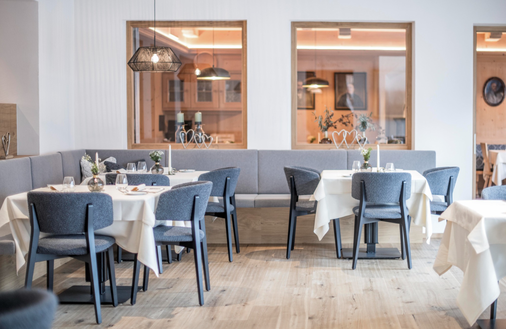 Dining room with white, covered tables and gray chairs - Hotel Wieser